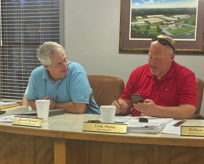 DUPUY'S FINAL REGULAR SCHOOL BOARD MEETING - Cleveland County School Board President Harrell Wilson (left) looks on as Superintendent Craig Dupuy (right) goes over an agenda item during Monday night's regular monthly school board meeting. Barring the need for a special meeting between now and June 30, it was the final time for him to meet with the school board before leaving for a new job as assistant superintendent for the Benton School District on July 1.