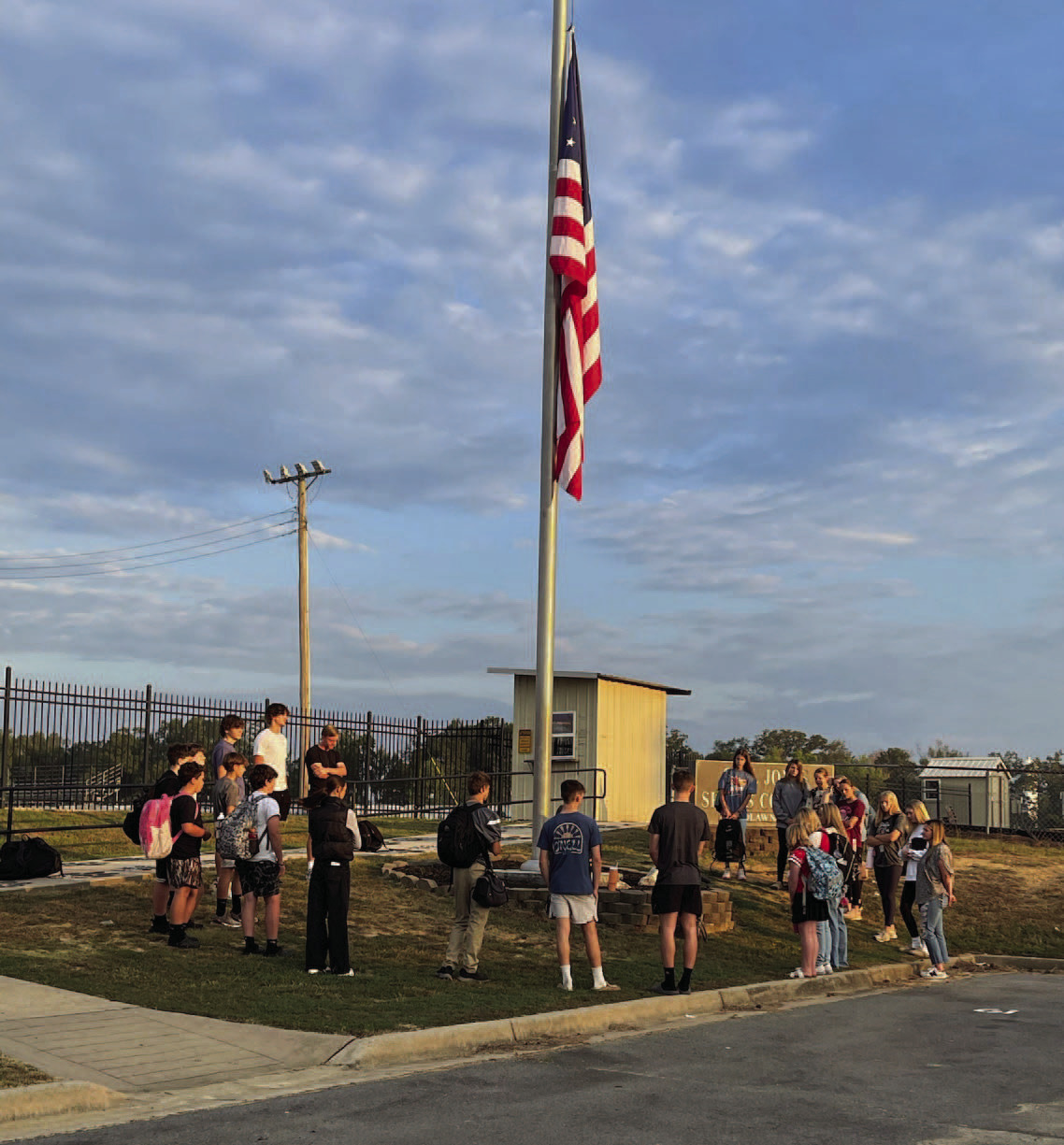 PRAYING FOR PEACE - The Woodlawn High School Fellowship of Chri stian Athletes (FCA) meet at the flagpole before school every Thursday for prayer. Last Thursday, Sept. 11, Lindsey Tooke requested through social media for parents and students to meet at 7:30 a.m. to pray for our country, our community and our leaders after the assassination of conservative pundit Charlie Kirk at the Utah Valley University and the school shooting in Colorado, as well as remembering the anniversary of 9-11.