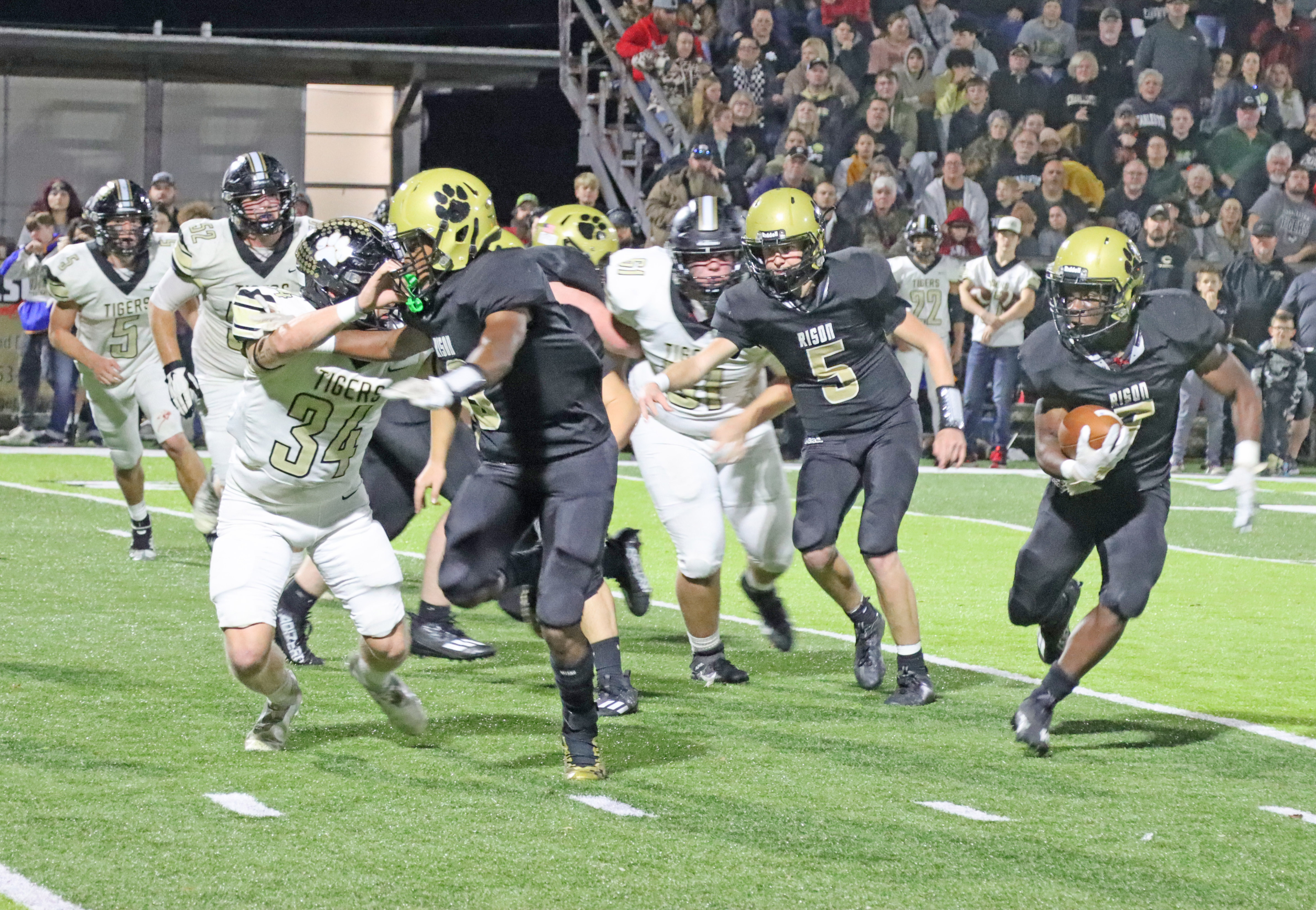 TESTING THE EDGE - Rison’s ZaKyler Walker (left, no. 3) looks to set a block on Charleston’s Bryton Keller (no. 34) as DJ Kines (right) looks to break outside after taking the handoff from quarterback Blaine Dixon (no. 5). The Wildcats’ two senior running backs, Kines and Bradyn Dupuy, led Rison in rushing with 69 and 66 yards, respectively. (Photo by Chris Phillips)