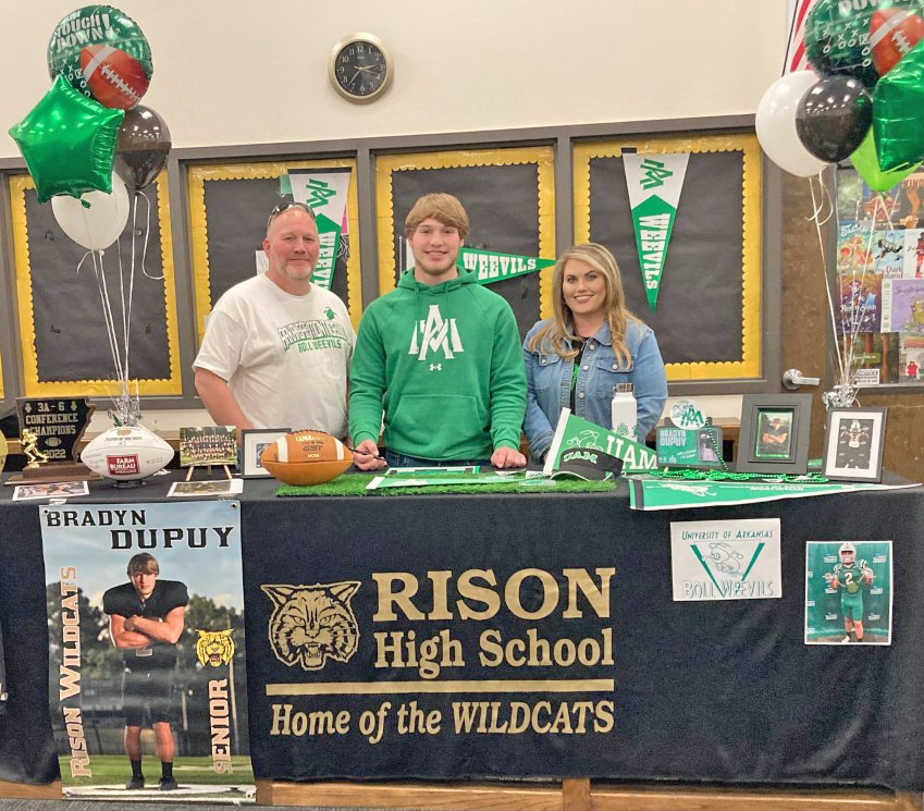 Bradyn Dupuy (center) poses for a photo with parents, Craig and Laura Dupuy, before signing with the UAM Boll Weevils.