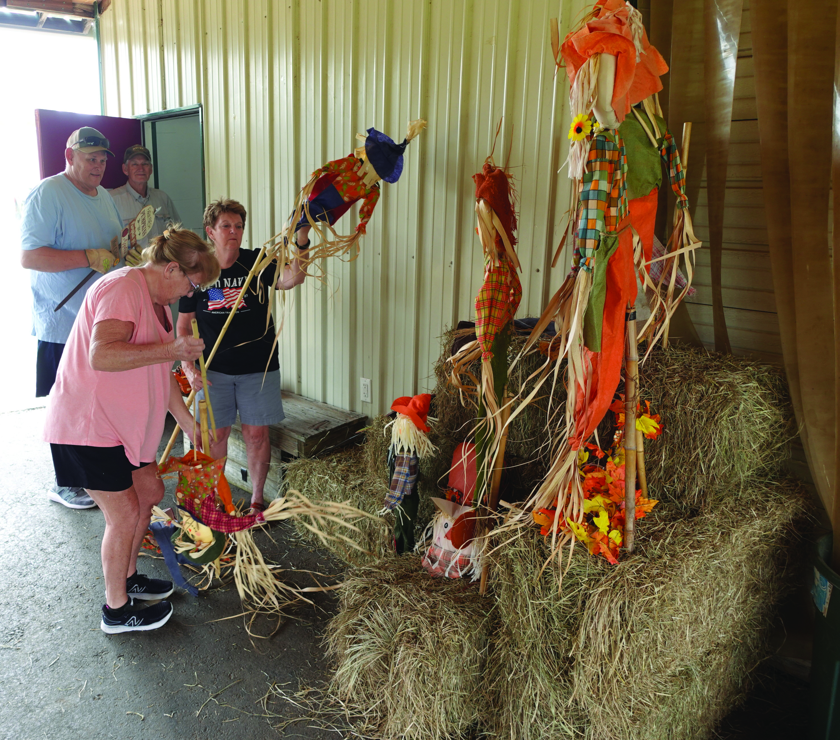 GETTING READY FOR THE COUNTY FAIR - Volunteers with the Cleveland County Fair Board work on decorations leading in the exhibit hall Tuesday after in preparation for this year's Cleveland County Fair. The fair is accepting entries today in anticipation of the fair being open to the general public Thursday through Saturday. Pictured are (back, left to right) David Kemp and John Appleget; and (front, left to right) Trenna Kemp and Patricia McClellan.