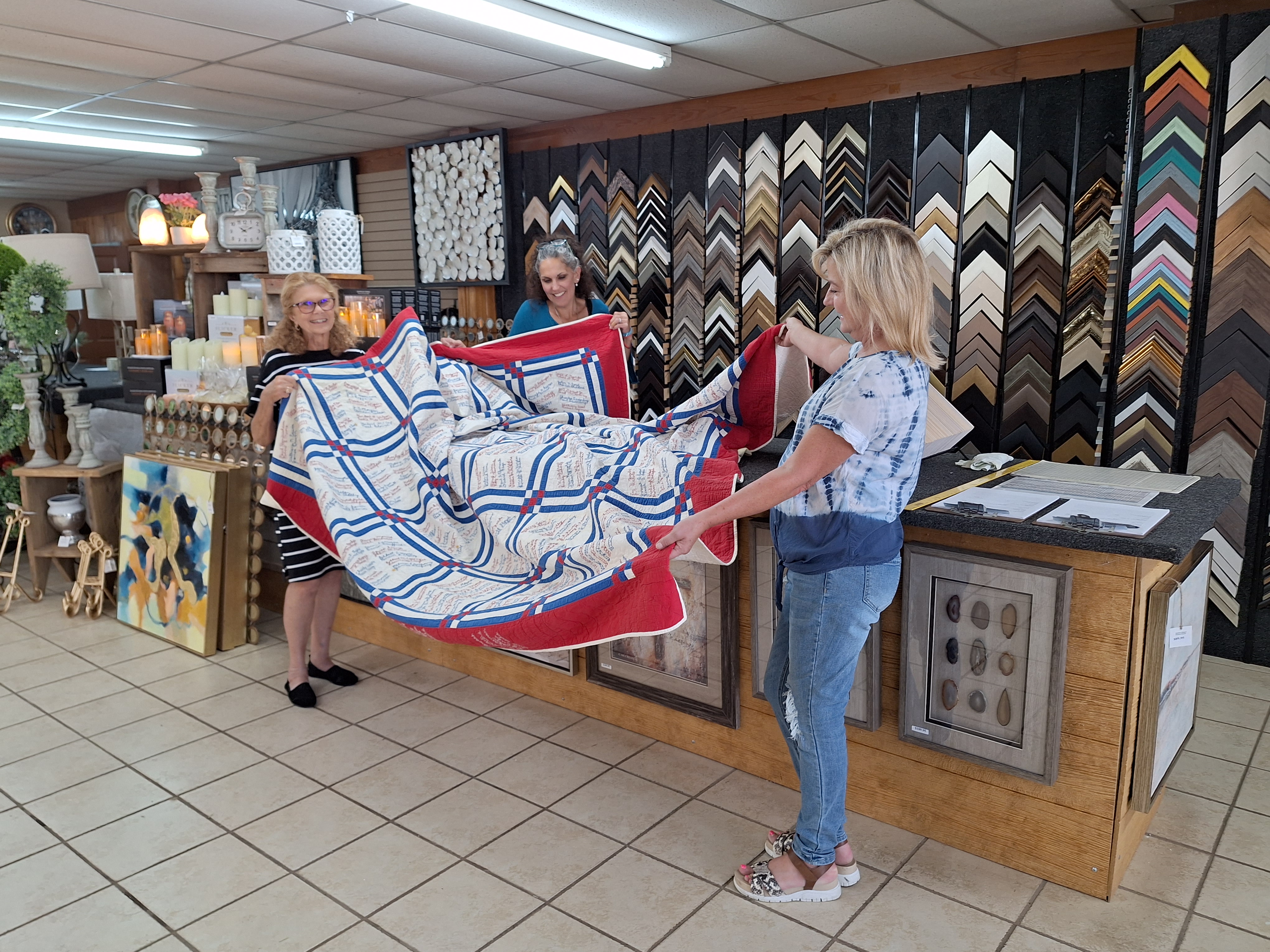 Karen Bell Fox with the Watson Chapel Picture Frame staff preparing the quilt for framing