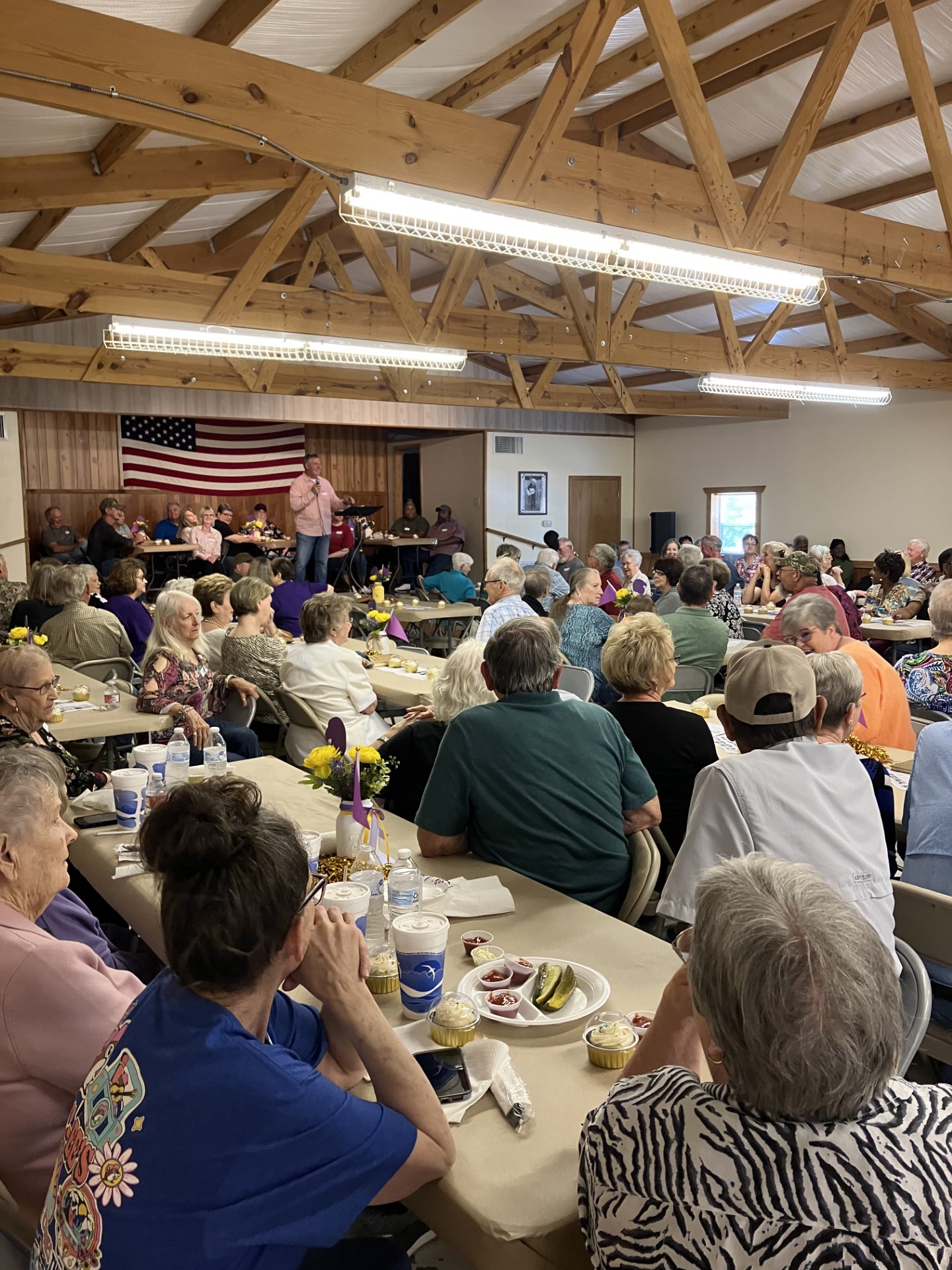 Roger McClellan (standing on stage) welcomes visitors to the New Edinburg All-School Reunion held this past Saturday, April 27, at the New Edinburg Community Center.