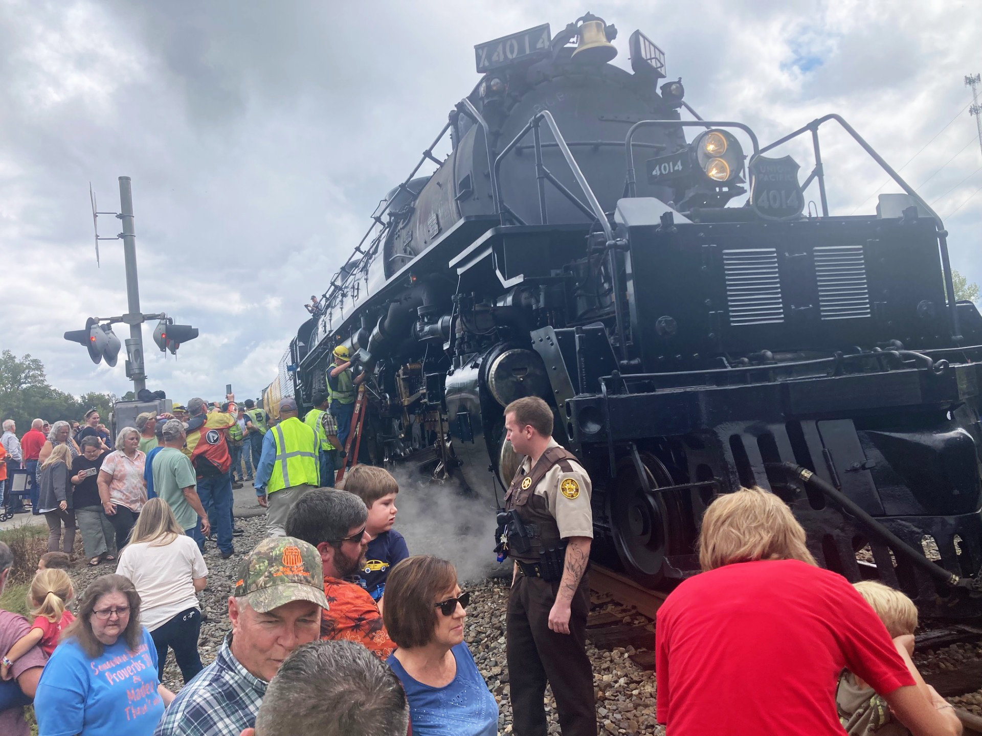 SERVICING BIG BOY NO. 4014 - Spectators engulf Union Pacific's Big Boy No. 4014, the world's largest operating team engine, when it made a "whistle stop" at the Maple Street crossing shortly late Monday morning in Kingsland. In the center of the photo, a service crew with Union Pacific refills the lubricants to the wheel system. Ed Dickens, ebngineer of the train and manager of Union Pacific's Heritage Operations, said Big Boy has to be serviced about every 80 to 100 miles.