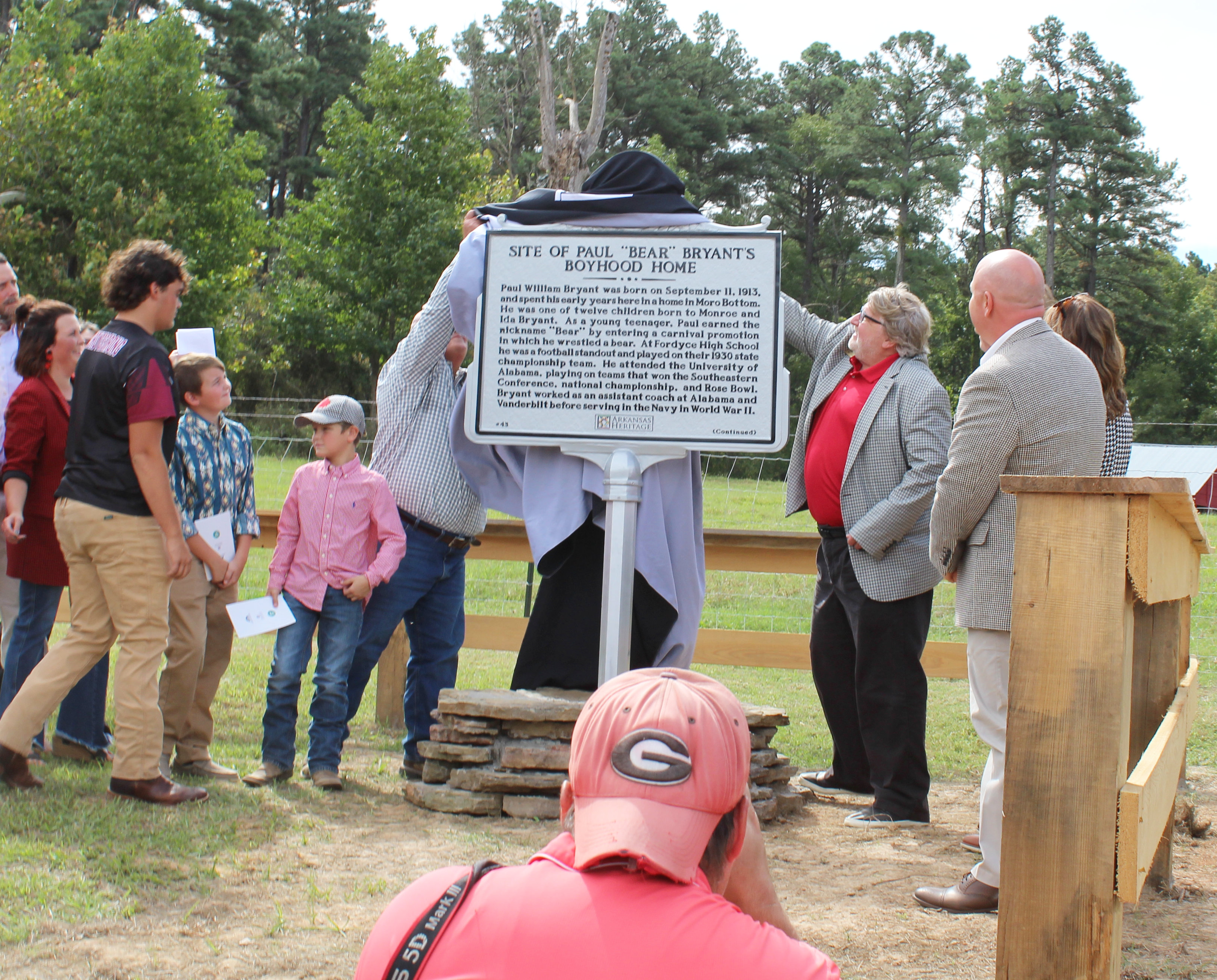 NEW MARKER FOR COACH PAUL “BEAR” BRYANT - Family members of the late Coach Paul “Bear” Bryant (left) and Marty Ryall, director of Arkansas Heritage, unveiled a new state historical marker designating the boyhood home of the legendary college football coach. Born in 1913 in Moro Bottom, Bryant grew up near the Smith Chapel community in southwestern Cleveland County. The marker is located on Hwy. 8 between Fordyce and New Edinburg.