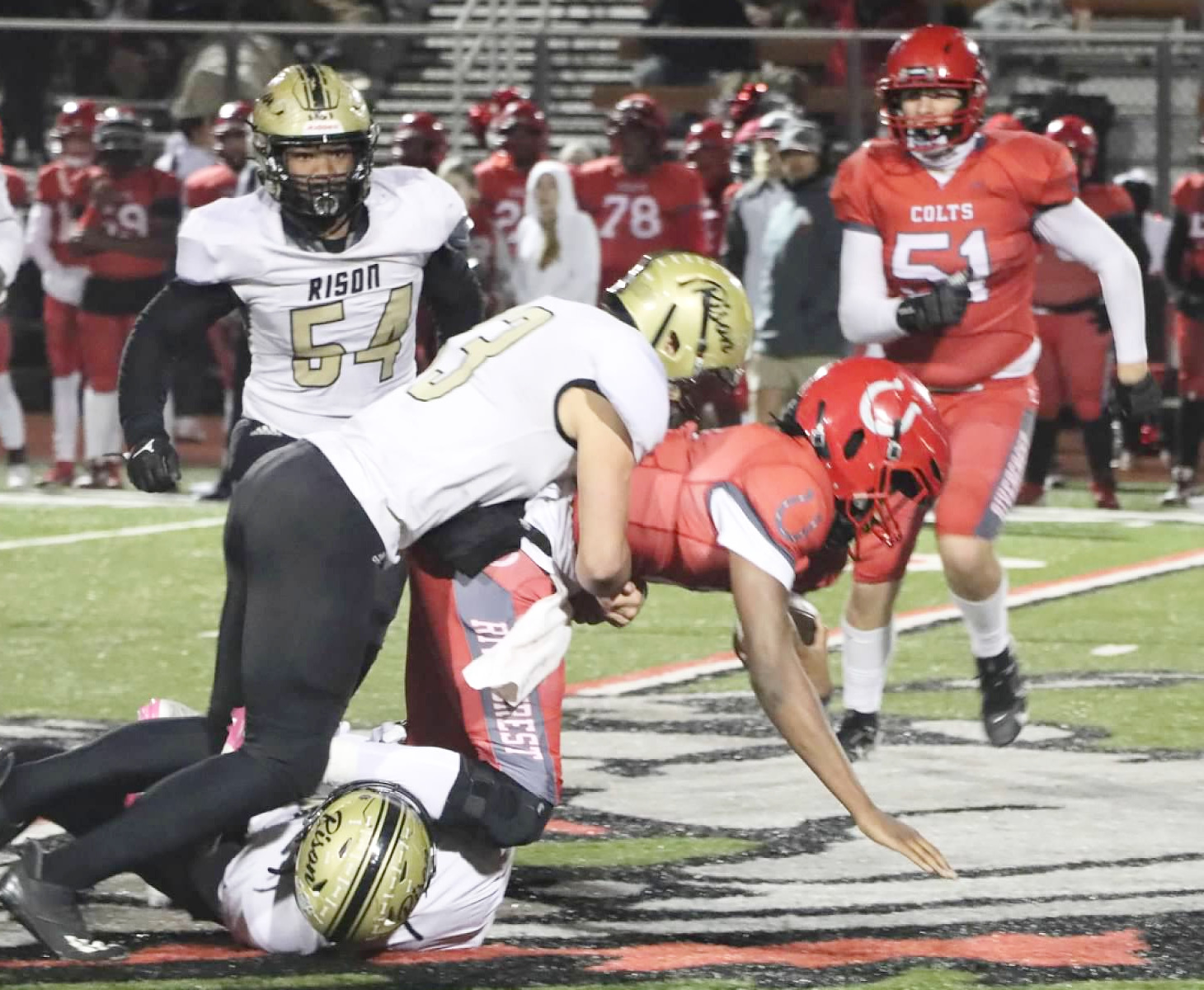 MAKING THE STOP - Rison’s Jaquis Rauls (bottom) grabs the legs of Rivercrest quarterback Cavonta Washington as teammate Eli Turner comes in to finish up the tackle in first half action of the Wildcats’ second-round playoff game at Rivercrest. Also pictured for Rison is Galvin Wilson, Jr. (no. 54 in background). (Photo by Chris Phillips)