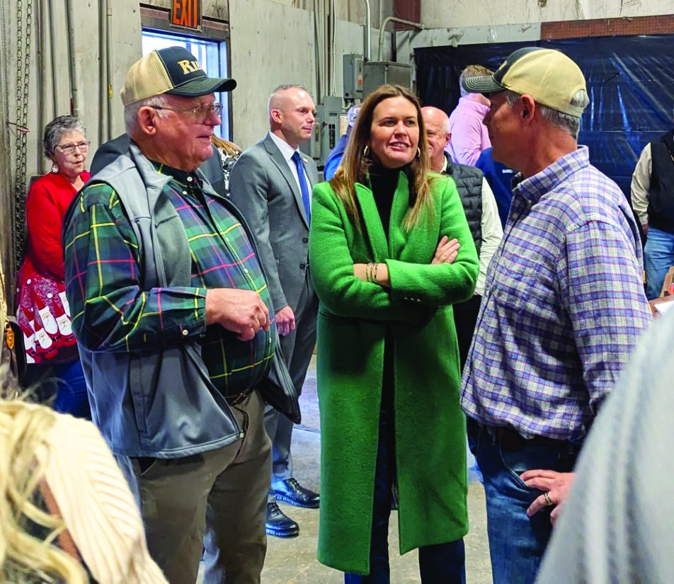 Gov. Sarah Sanders (center) visits with Frank Wilson (left) and Harrell Wilson (right) during the Wilson Brothers Lumber Company Christmas Barbeque held Tuesday at the Wilson Brothers shop on Hwy. 35 at the Staves community.   Hundreds of people ranging from sawmill workers to politicians enjoy a large plate of brisket, pulled pork and ribs at the annual event. The governor took time to take photos with many of those attending the event. 
