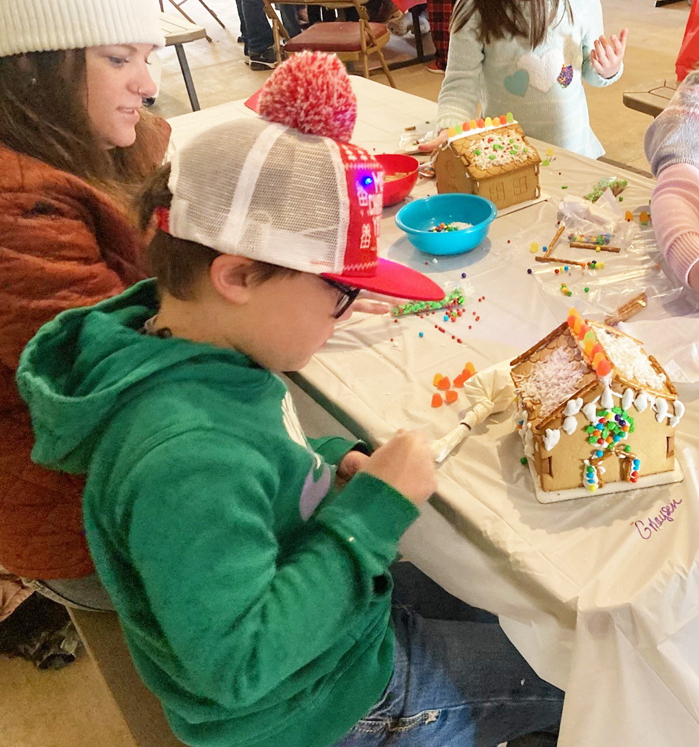 CREATING A MASTERPIECE - Greyson King intently works on his gingerbread house during The Call in Cleveland County’s Gingerbread House Workshop and Contest held Saturday during Christmas in the Village at the Pioneer Village in Rison. After completing their gingerbread houses, each house was entered in a contest sponsored by the Cleveland County Herald. King finished second in the 12 and Under division.