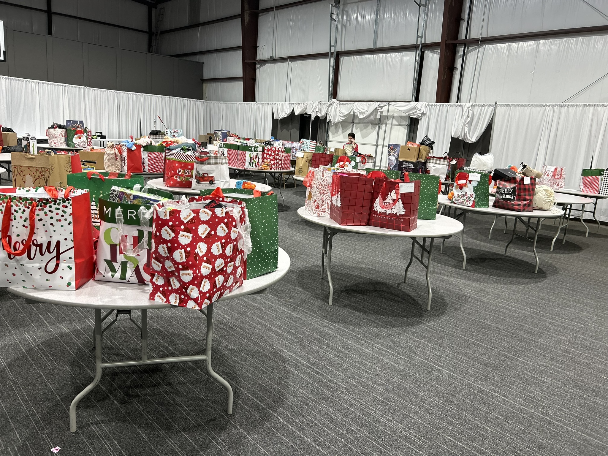  CHRISTMAS GIFTS EVERYWHERE YOU LOOK - If you look closely among these tables filled with gifts, you will see one of the key coordinators of the Cleveland County Cares p roject, Carol Dollar. Dollar, helps facilitate the distribution of gifts to families in need during the holidays with lead organizer Melinda McKnight. This year an estimated 80 children will receive gifts for Christmas, an incr ease of nearly 30 from the previous year. (Photo by Melinda McKnight)