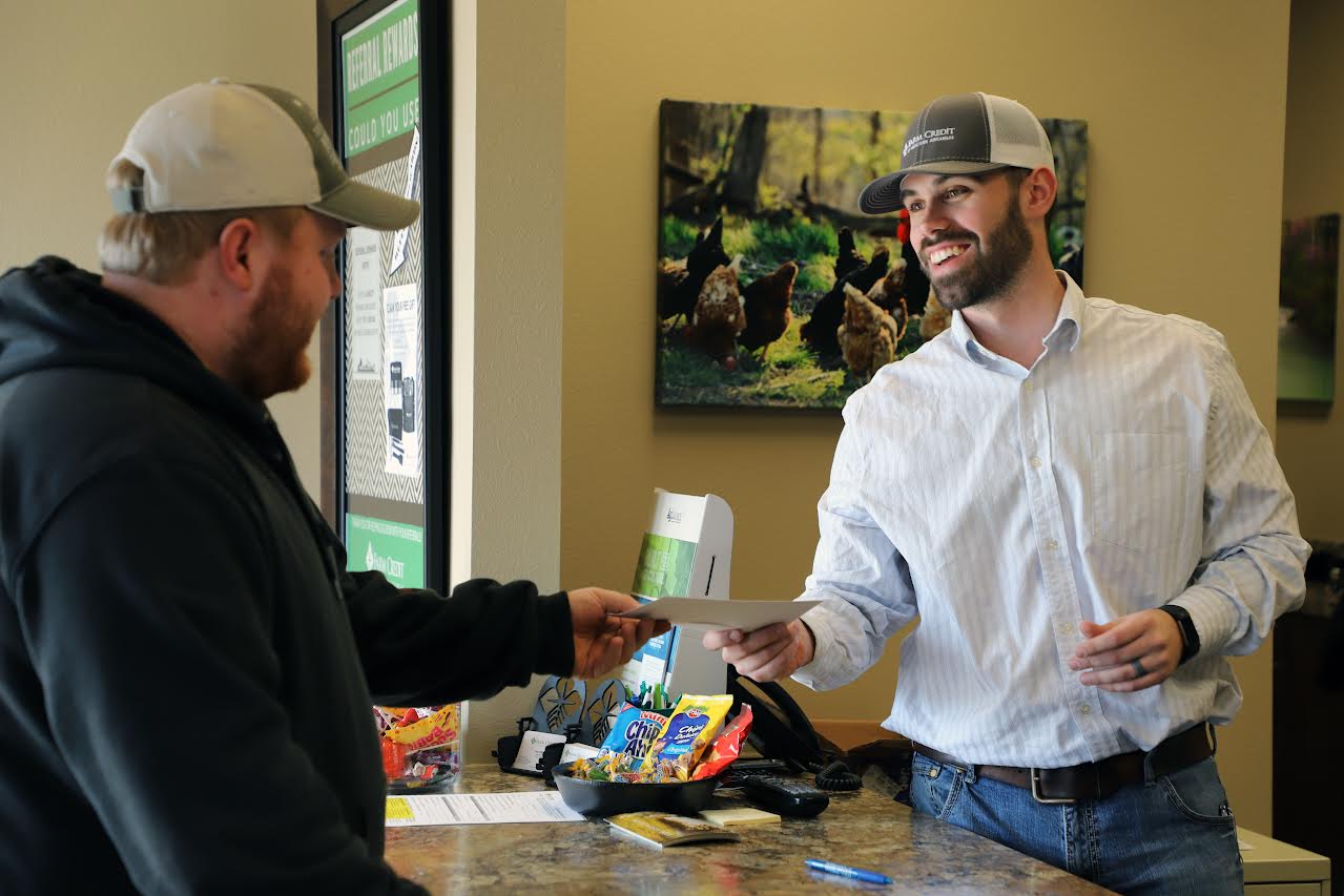 Trey Villines of the Huntsville Farm Credit branch office distributes a patronage check to a customer.