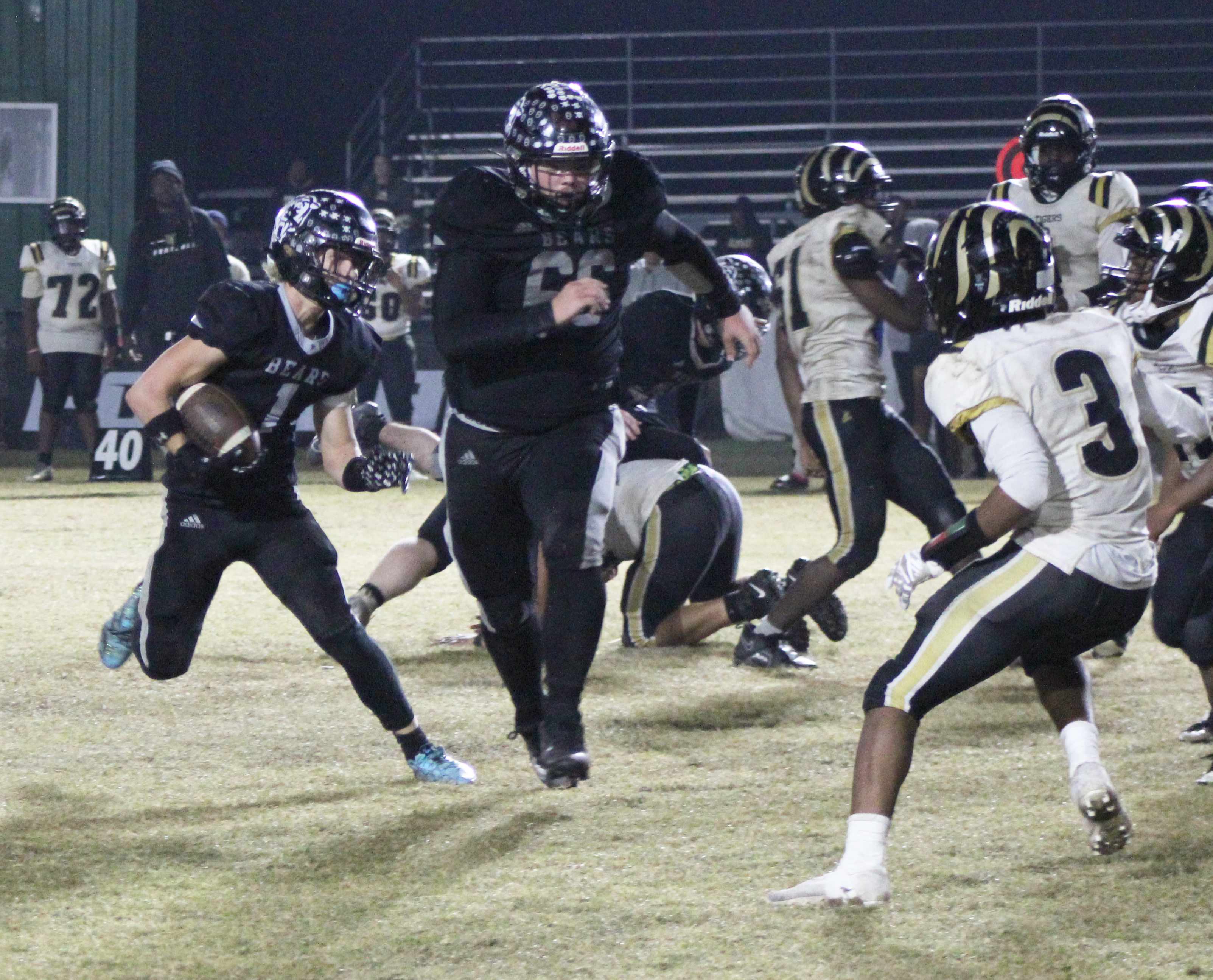 PAVING THE WAY - Woodlawn running back Griffin Manes (1) follows senior lineman Dakota Campbell (66) for another gain in the Bears’ 50-18 win over the Brinkley Tigers Friday night at the Carl Jones Sports Complex. Manes, who broke 1,000 yards rushing for the season last week, finished with 124 yards on 25 carries, and took much of the rushing load in the second half after quarterback Ethan Saeler had to leave the game with an injury late in the second quarter.