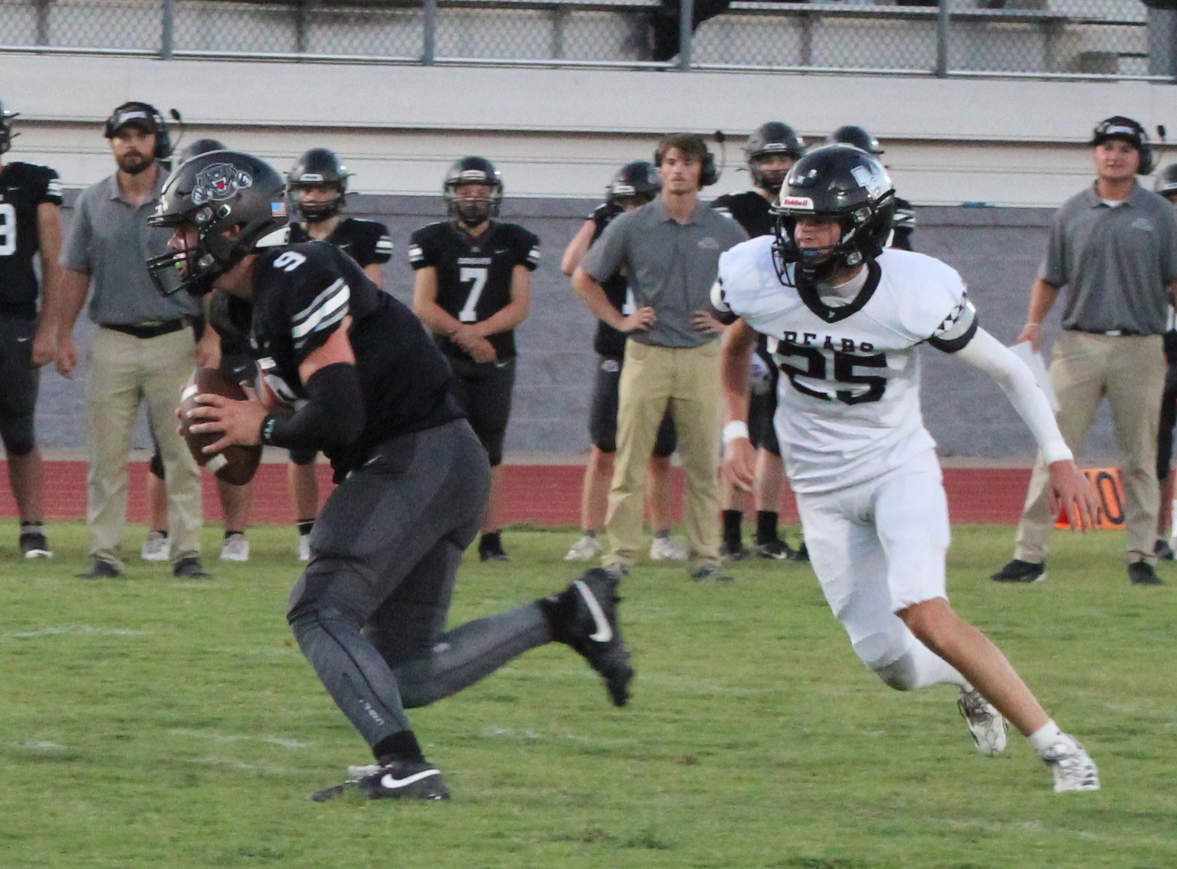 HANDFUL TO HANDLE - Woodlawn’s Brayden Jones (right, 25) pursues Izard County sophomore quarterback Kane Johnson during first half action of Friday’s non-conference game at Cougar Stadium in Brockwell. Johnson had it going through the air and one the ground as threw for 212 yards and six touchdowns while rushing 15 times for 119 yards. Johnson never left the game.