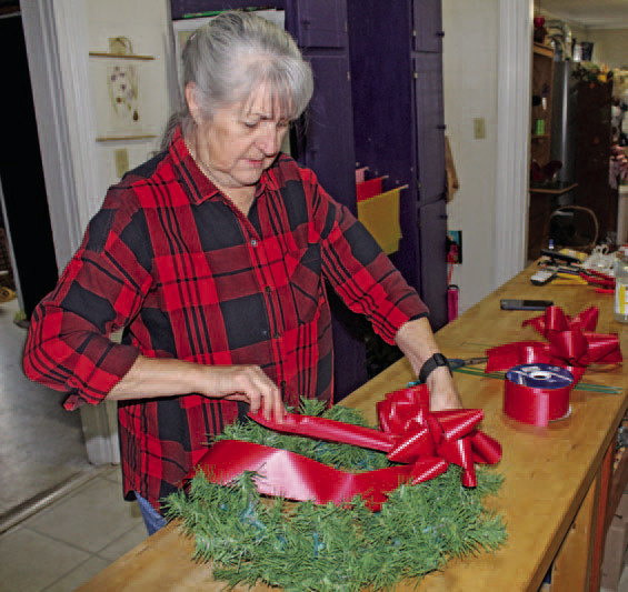 CHRISTMAS TIME IS COMING! - Malinda Berry of My Berry Patch in Rison puts together a red bow for one of the Christmas wreaths that will be put up by Rison Shine on the lamp posts along Main Street in downtown Rison.