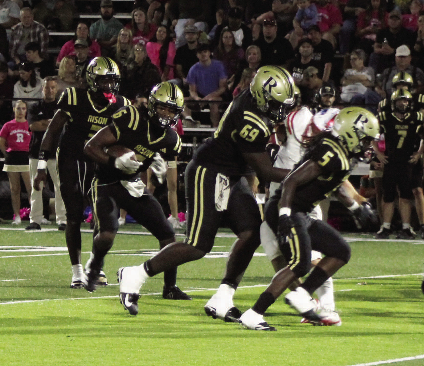 DOMINATING RUN GAME - Rison quarterback Kyson Walker (left, 3) hands off to running back Jaquis Rauls (second from left, 6) as he follows the blocks of Javis McGhee (69) and Jeremiah Marshall (5) for a gain Friday night against Palestine-Wheatlery. Walker finished with 230 yards rushing and four touchdowns as the Wildcats amassed 421 yards rushing. Marshall had 128 yards on the ground while Rauls scored what turned out to be the winning touchdown late in the fourth quarter.