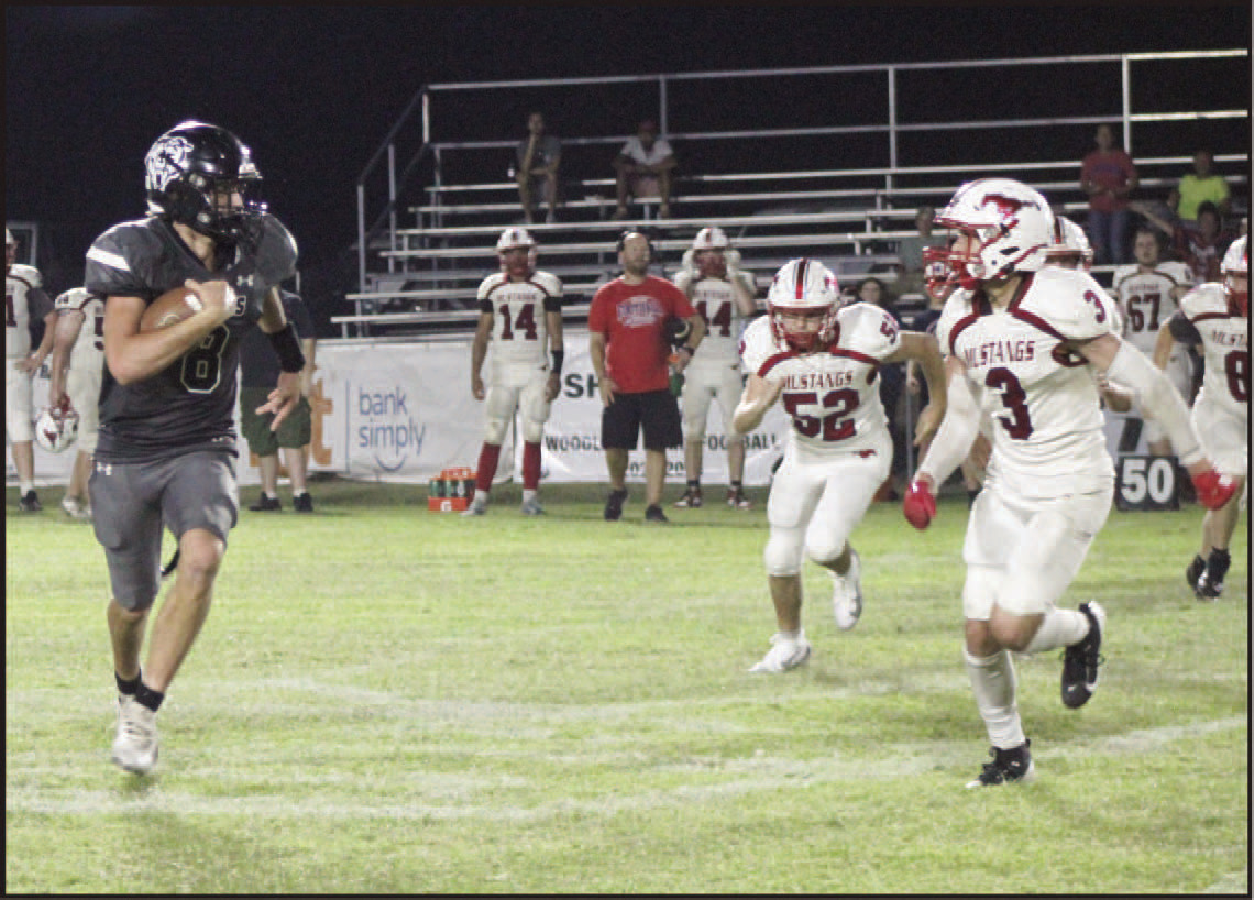 FINDING THE EDGE - Woodlawn quarterback Ethan Saeler looks to get outside the Midland pursuit during second half action Friday night at the Carl Jones Sports Complex. After finishing the first half with three yards rushing on five carries, Saeler blistered the Mustang defense in the second half as he ran for 168 yards on 13 carries with three touchdowns. He also started the second half with a 57-yard kickoff return for a touchdown.