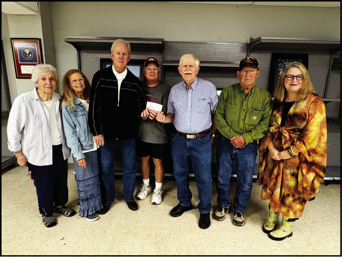 HISTORICAL SOCIETY DONATES TO VETERANS ASSOCIATION DISPLAY - Members of the Cleveland County Historical Society pr esented a $500 check to the Cleveland County Veteran's Association to help fund glass cases for the display being installed in the Hall-Morgan Veteran's Building. Pictured are Annette Rawls, Karen Bell Fox, Wayne Cash, Randy Morgan, Rickey Fore, Allen Wilson and Suzi Parker.