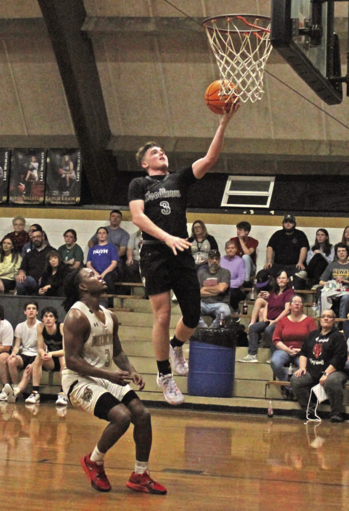 WEATHERFORD GETS RED HOT - Woodlawn's Garrett Weatherford drive a layup against Rison's Za'Kyler Waker during second half action of the regular season finale last Friday night inside the Rison Gym. Weatherford buried four of his five 3-pointers in the third quarter as the Bears pulled away for the 76-48 victory.