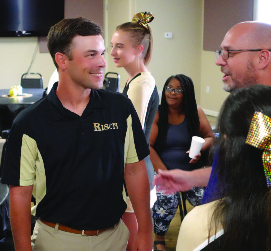 SEEING FLASHES - New Rison Coach Caleb Carmikle (left) visits with Thomas Burns during a "Meet &amp; Greet" for Rison High School's new coaches held last Thursday evening by Bethel #1 Missionary Baptist Church near Rison. Carmikle said he has seen "flashes" of what this year's team is capable of during team camps and 7-on-7's over the summer. However, he said there needs to be more consistency to become what he described as being a "good football team."
