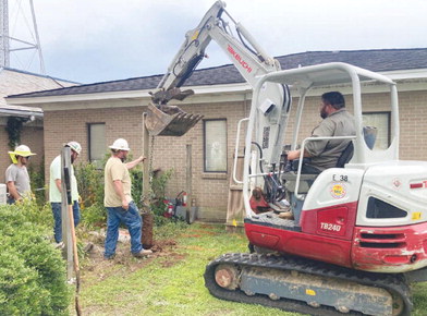 POWER RESTORATION - A crew from Southern Electric Corporation removed a fence post in order to get to beginning digging up three underground power lines that feed electricity the Cleveland County Courthouse and the Cleveland County Sheriff's Department.