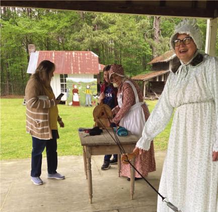 MAKING ROPE - Gina Brown (foreground) and Shorty Drye (backgrou nd in bonnet), both volunteer demonstrators with the Pioneer Village, spin pieces of thread together to form a rope during Saturday's Pioneer Crafts Festival. It was one of several live demonstrations held during the event.