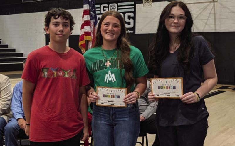 Aidan Womack presents the Josh Womack Memorial Scholarship to Lillianna Holmes and Kelsi Mack