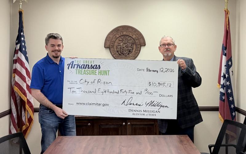 CITY OF RISON FINDS ITS OWN TREASURER - Thomas Burchfield (left) of the State Auditor’s office presents Rison Mayor Charles Roberts (right) with a check for $10,845.12. Roberts said he discovered the city had the unclaimed money while visiting the State Auditor’s booth at the Arkansas Municipal League meeting in Hot Springs over the weekend.