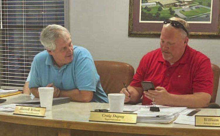 DUPUY'S FINAL REGULAR SCHOOL BOARD MEETING - Cleveland County School Board President Harrell Wilson (left) looks on as Superintendent Craig Dupuy (right) goes over an agenda item during Monday night's regular monthly school board meeting. Barring the need for a special meeting between now and June 30, it was the final time for him to meet with the school board before leaving for a new job as assistant superintendent for the Benton School District on July 1.