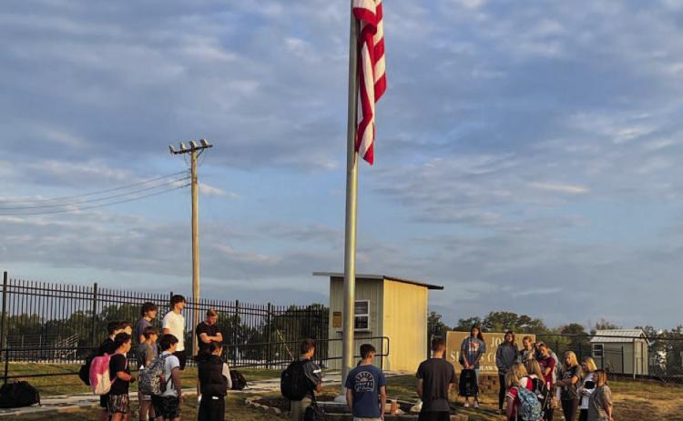 PRAYING FOR PEACE - The Woodlawn High School Fellowship of Chri stian Athletes (FCA) meet at the flagpole before school every Thursday for prayer. Last Thursday, Sept. 11, Lindsey Tooke requested through social media for parents and students to meet at 7:30 a.m. to pray for our country, our community and our leaders after the assassination of conservative pundit Charlie Kirk at the Utah Valley University and the school shooting in Colorado, as well as remembering the anniversary of 9-11.
