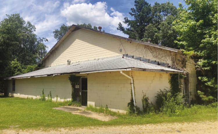 GYM IN DISREPAIR - This shot of the former New Edinburg School gym shows its current condition. Besides vines covering the sides of the building, the inset shows a large hole in the roof over the lobby area.