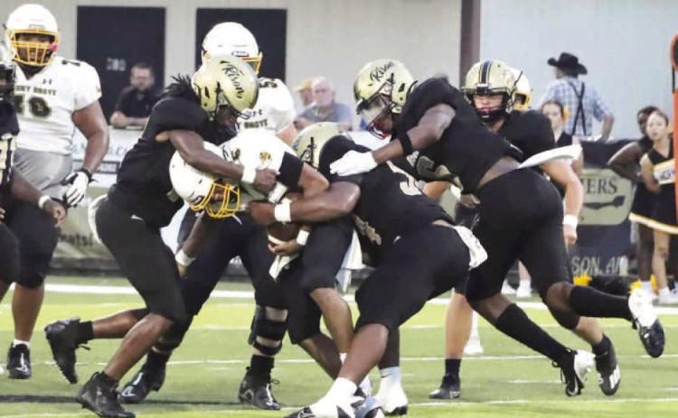 DEFENSE STEPS UP - Rison's (left to right) Keyshawn Haywood, Ga lvin Wilson, Jr. and Jaquis Rauls wrap up Harmony Grove quarterback Damien Rauls for a loss during first half action Friday night. The Hornets netted just 86 yards of offense in the game. (Photo by Chris Phillips)