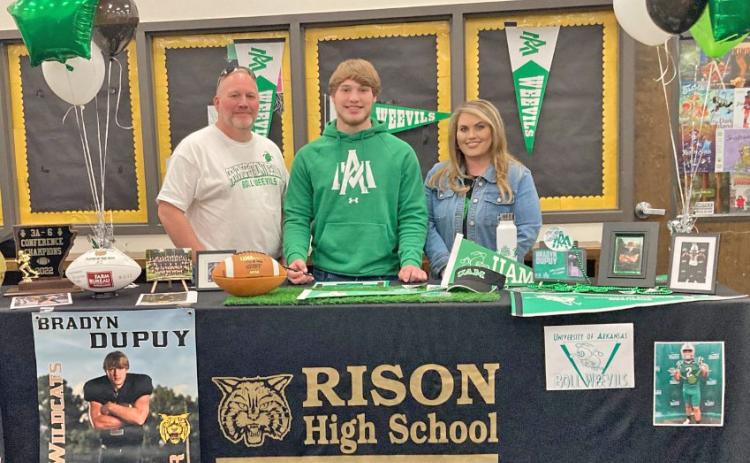 Bradyn Dupuy (center) poses for a photo with parents, Craig and Laura Dupuy, before signing with the UAM Boll Weevils.