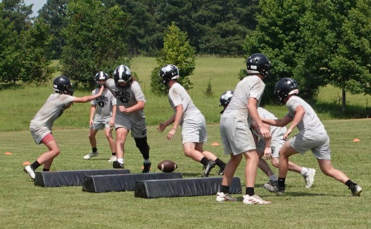 The Woodlawn Bears' defensive line executes a play during their second day of preseason drills on the practice field behind the Carl Jones Sports Complex. Woodlawn is coming off a 9-2 season where the Bears advanced to the Class 2A eight-man state semifinals before falling at Izard County, 62-56, on the last play of the game. Izard County went on to win the state title.