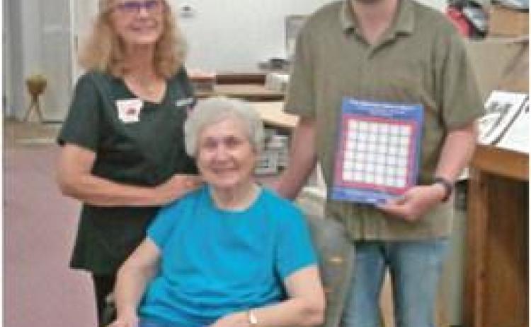 EHC, HISTORICAL SOCIETY COMPLETE WWII QUILT BOOKLET - Karen Bell Fox (left) with the Extension Homemakers Council, Annette Rawls (center) with the Cleveland County Historical Society, and Douglas Boultinghouse, graphic designer at the Cleveland County Herald, get their first look at the World War II Service Men's Quilt booklet. The booklets are available for purchase now.