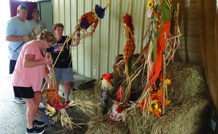 GETTING READY FOR THE COUNTY FAIR - Volunteers with the Cleveland County Fair Board work on decorations leading in the exhibit hall Tuesday after in preparation for this year's Cleveland County Fair. The fair is accepting entries today in anticipation of the fair being open to the general public Thursday through Saturday. Pictured are (back, left to right) David Kemp and John Appleget; and (front, left to right) Trenna Kemp and Patricia McClellan.
