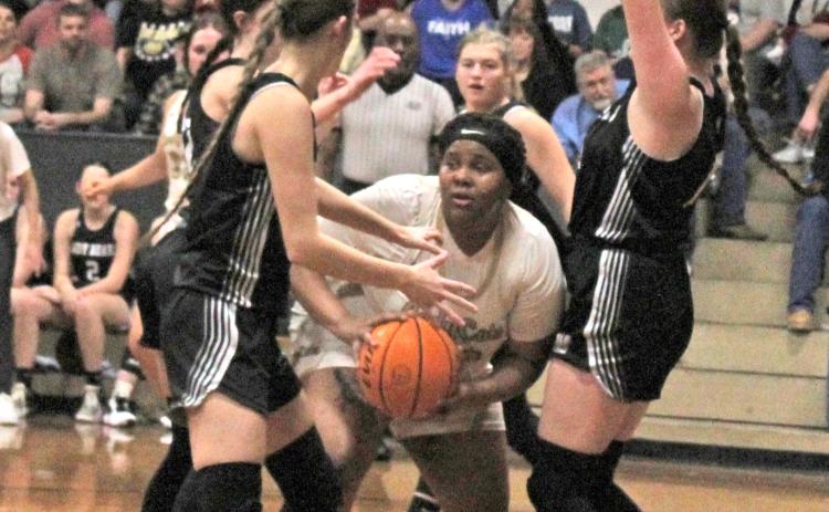 TOUGH INSIDE - Rison’s R’erel Roshell (center) looks for relief as she is finds herself surrounded by Woodlawn’s Kathryn Dixon (left) and Lillie Faye McWhorter (right) in last Friday’s battle between the Cleveland County rivals. The Lady Bears saw their 19-point second half lead cut to three in the fourth quarter before holding on for the 45-41 win.