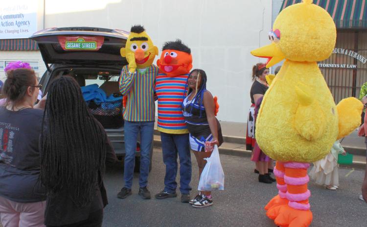 RISON SHINE TRUNK-OR-TREAT - A trunk-or-treater poses with characters form Sesame Street that were one of the “trunkers” at the Rison Shine Trunk-or-Treat held along the 200 block of Main Street in downtown Rison. An estimated 1,000 people took part in the event. While usually held on Halloween night, Trunk-or-Treat was moved to Tuesday night due to the Rison-Fordyce junior high football game being held Thursday night.