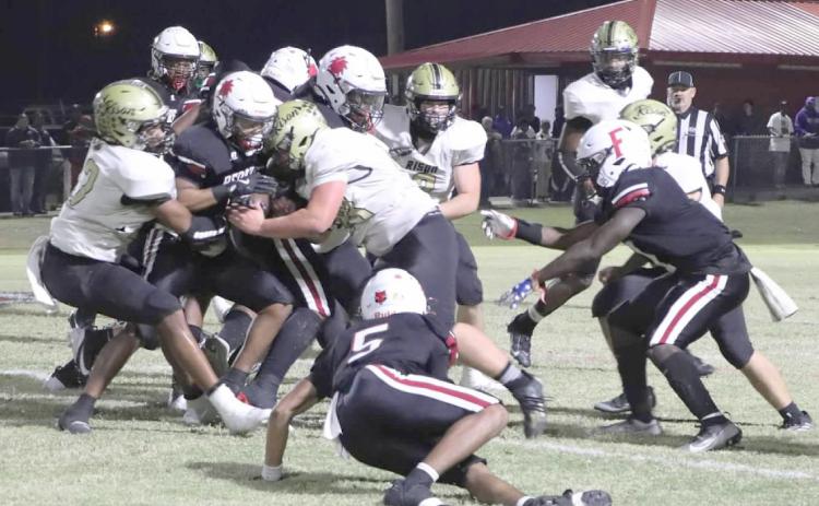 RUN STOPPERS - Rison’s Chandler Reeves (left no. 32) and Thomas Wilson (right no. 53) close in to stop Fordyce running back Brenton Sledge at the line of scrimmage in first quarter action of last Friday’s 8-3A battle before packed house at Paul “Bear” Bryant Stadium in Fordyce. The Wildcat defense held the Redbugs to 127 yards rushing in the game. (photo by Chris Phillips)