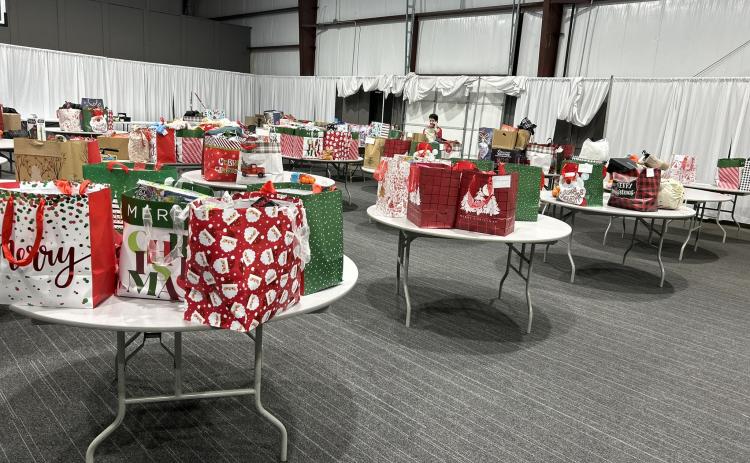 CHRISTMAS GIFTS EVERYWHERE YOU LOOK - If you look closely among these tables filled with gifts, you will see one of the key coordinators of the Cleveland County Cares p roject, Carol Dollar. Dollar, helps facilitate the distribution of gifts to families in need during the holidays with lead organizer Melinda McKnight. This year an estimated 80 children will receive gifts for Christmas, an incr ease of nearly 30 from the previous year. (Photo by Melinda McKnight)