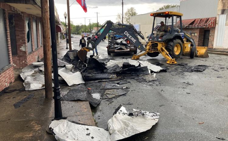 The City of Rison street crew works to remove pieces of the roof from the former Cash’s AG Grocery Store from the 200 block of Main Street Thursday afternoon.