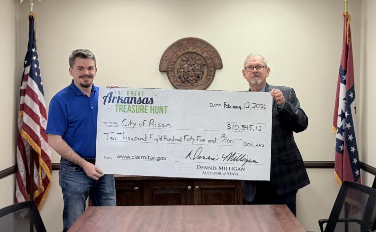 CITY OF RISON FINDS ITS OWN TREASURER - Thomas Burchfield (left) of the State Auditor’s office presents Rison Mayor Charles Roberts (right) with a check for $10,845.12. Roberts said he discovered the city had the unclaimed money while visiting the State Auditor’s booth at the Arkansas Municipal League meeting in Hot Springs over the weekend.