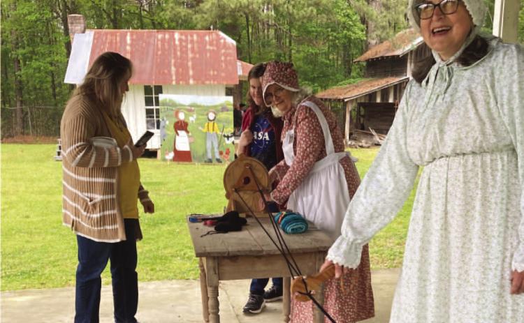 MAKING ROPE - Gina Brown (foreground) and Shorty Drye (backgrou nd in bonnet), both volunteer demonstrators with the Pioneer Village, spin pieces of thread together to form a rope during Saturday's Pioneer Crafts Festival. It was one of several live demonstrations held during the event.