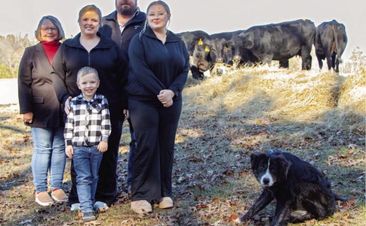 FARM FAMILY OF THE YEAR - Jason and Ashley Boyd (center) of Ris on were named the Cleveland County Farm Family of the Year 2024. The couple are pictured with two of their children Taylor (right) and Wyatt (front), Jason's mother, Pat (far left). Daughter Haley is not pictured. The family's dog Festus joined them for a photo after herding the cows.