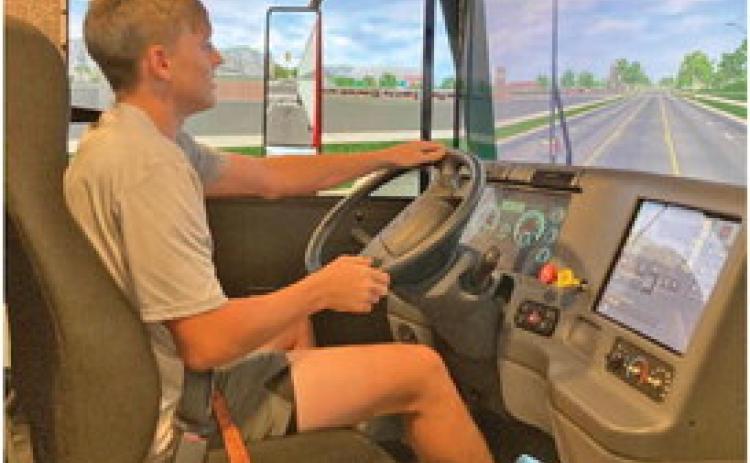 Woodlawn junior Garrett Weatherford tries his hand at driving a big rig in the semi simulator.