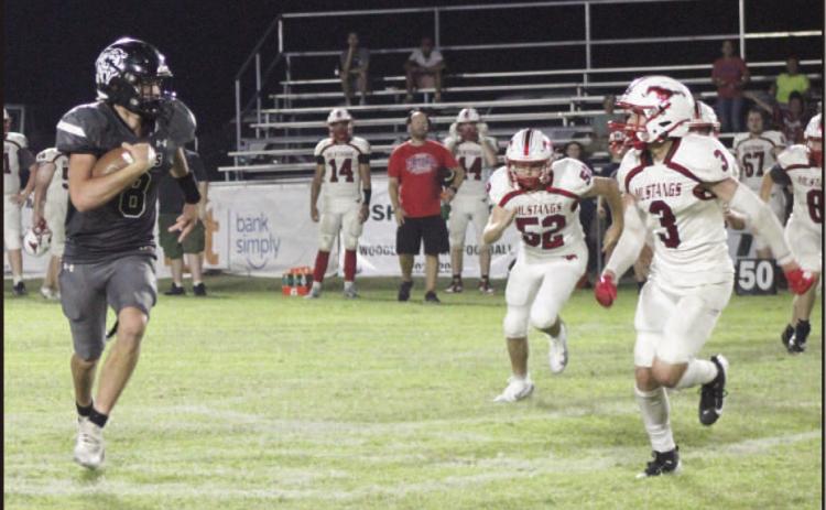 FINDING THE EDGE - Woodlawn quarterback Ethan Saeler looks to get outside the Midland pursuit during second half action Friday night at the Carl Jones Sports Complex. After finishing the first half with three yards rushing on five carries, Saeler blistered the Mustang defense in the second half as he ran for 168 yards on 13 carries with three touchdowns. He also started the second half with a 57-yard kickoff return for a touchdown.