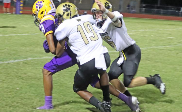 BIG DEFENSIVE NIGHT FOR HEARD - Rison sophomore Keyshawn Heard (no. 19) wraps up Dumas’ Jaylyn Jones as teammate James Mitchell (no. 6) closes in to assist during the Wildcats’ season-opening victory Friday night at Dumas. Heard finished with five tackles and a pass break-up in his varsity debut.