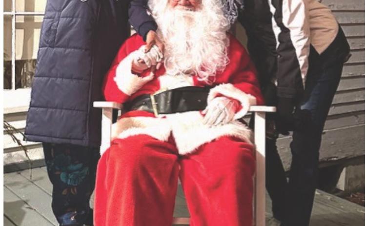 VISITING SANTA - Virginia Brewer (left) and her daughter Sheila Smith (right) visited with Santa during the Pioneer Village's drive-thru lights event this past Friday night. Photo by Marty Bowlin.