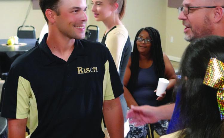 SEEING FLASHES - New Rison Coach Caleb Carmikle (left) visits with Thomas Burns during a "Meet &amp; Greet" for Rison High School's new coaches held last Thursday evening by Bethel #1 Missionary Baptist Church near Rison. Carmikle said he has seen "flashes" of what this year's team is capable of during team camps and 7-on-7's over the summer. However, he said there needs to be more consistency to become what he described as being a "good football team."