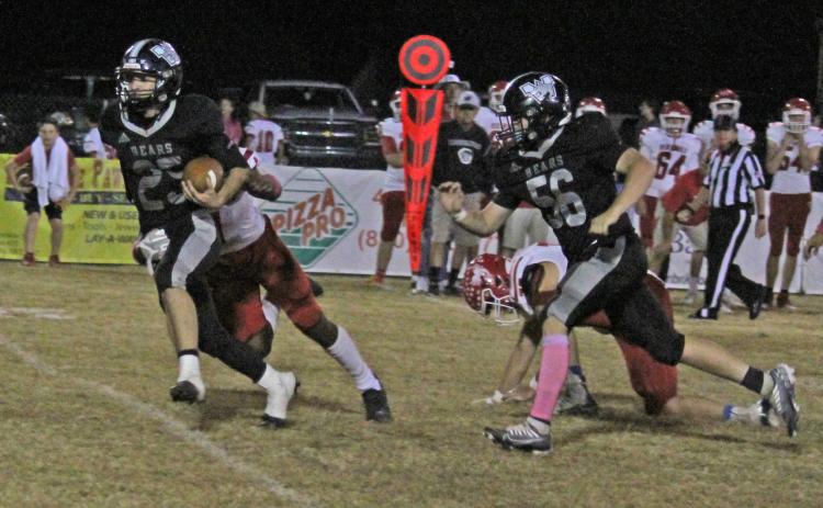 HALE TURNS IN BIG GAME - Woodlawn senior Fisher Hale (left, no. 25) picks up a first down for the Bears during first half action Friday night in Woodlawn’s showdown with top-ranked Mountain Pine. Hale, a two-way starter, had one of his best overall performances of his career, rushing for a team-high 112 yards on 13 carries with a touchdown, and recording 10 tackles and an interception from his linebacker position on defense. Trailing on the play for the Bears is lineman Steven Adair.