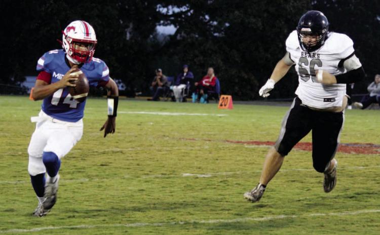 BIG NIGHT FOR CAMPBELL - Woodlawn defensive lineman Dakota Campbell (right) pursues Midland quarterback Chase Rascoe during first half action. Campbell had eight tackleswith seven of those going for losses. He also had a fumble recovery and was in on four third down stops.
