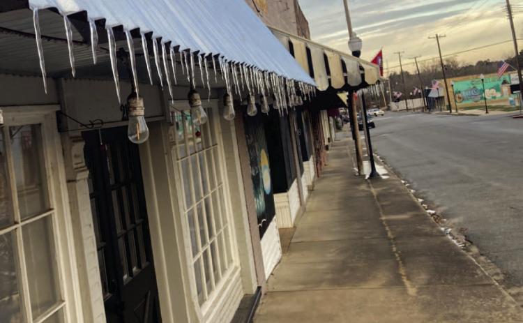 DISTANT MEMORY NOW - Icicles dangle from the edge of awnings in the downtown area of Rison last Thursday and Friday after Cleveland County was hit with a polar cold front last week. A round of light freezing rain, sleet and snow fell from Tuesday evening through Wednesday morning, coating roadways and roof tops in ice. After the sun came out Wednesday afternoon, much of that frozen precipitation melted and froze again overnight to form the icicles. Temperatures bounced back into the 70s by Tuesday.